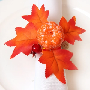 Herbstlicher Serviettenring mit Ahornblatt und Kürbis auf weißer Stoffserviette
