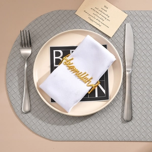 Golden Bismillah metal napkin ring on white cloth with elegant dinner table setting