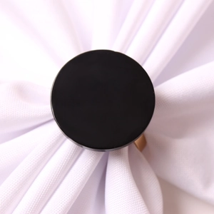 Modern black acrylic napkin ring with gold metal base on white fabric decoration