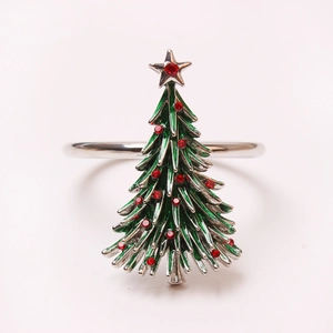 Close-up of a Christmas tree napkin ring with green enamel and red crystal accents