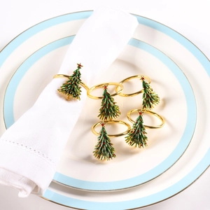 Close-up of golden Christmas tree napkin rings with green enamel and red beads