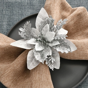 Sparkling silver glitter flower napkin ring on linen cloth for Christmas table decoration