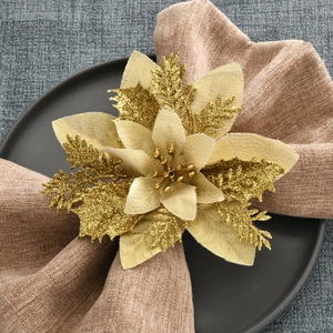 Champagne gold poinsettia napkin ring on a linen napkin for festive table decoration