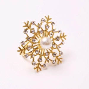 Detailed close-up of golden snowflake napkin ring with pearls and sparkling rhinestones