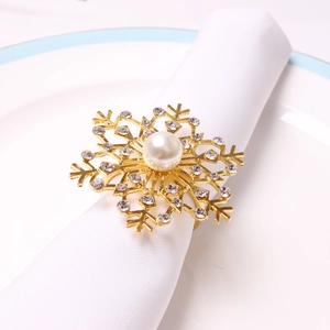 Detailed view of golden snowflake napkin ring with pearl and sparkling rhinestones