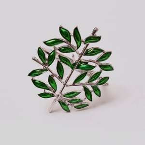 Detailed close-up of green enamel tree leaf napkin ring with silver metallic finish