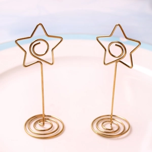 Golden star-shaped stainless steel card holder with spiral base for wedding table settings