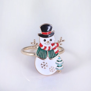 Detail of a festive snowman napkin ring with gold finish and colorful enamel coating