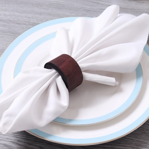 Minimalist walnut wood napkin ring with natural grain on white linen napkin table setting