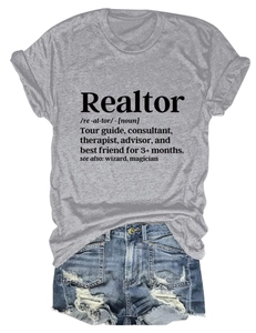 Dettaglio della scritta Realtor su t-shirt grigia con pantaloncini in denim strappati