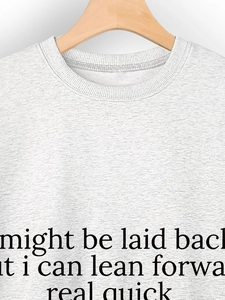 Detail of grey crewneck sweatshirt featuring black printed lettering on cotton fabric