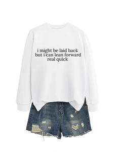 Flat lay of white crewneck sweatshirt with slogan and distressed denim shorts outfit