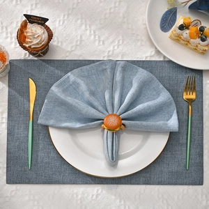 Realistic hamburger napkin ring with light blue cloth on a set dining table top view