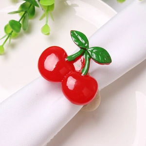 Detail shot of a double cherry napkin ring with green leaves on a wooden base