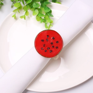 Detail of watermelon slice napkin ring on white fabric napkin in a bright dining setting