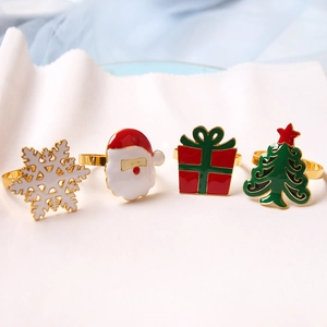 Set of four Christmas napkin rings featuring Santa, snowflake, and tree in enamel finish