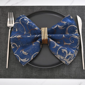 Modern square gold metal napkin ring set with navy baroque napkin and cutlery