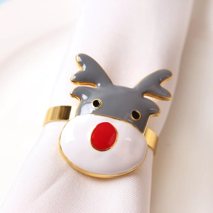 Detailed close-up of a festive reindeer napkin ring with red nose on a white cloth