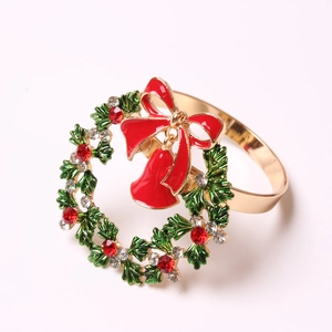 Servilletero navideño con base dorada, hojas de esmalte verde y campanas rojas de gala