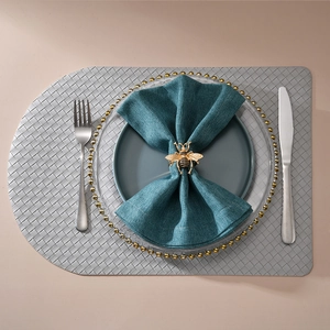 Elegante servilletero de metal con forma de abeja dorada en una servilleta de lino