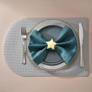 Matte gold star napkin ring on dark green cloth for festive table setting decor