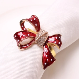 Red bow tie napkin ring with white polka dots and crystals on white linen