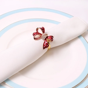 Red polka dot bow napkin ring with crystal rhinestones on a white linen napkin