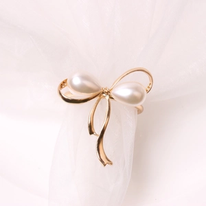 Elegant Christmas bow napkin ring with golden metal and pearlescent water-drop pearls
