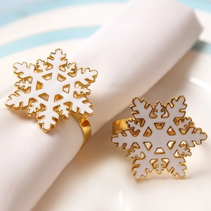 Elegant gold metal napkin rings with white snowflake design for festive table settings