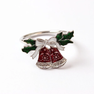 Détail macro du rond de serviette de Noël avec feuilles de houx et cloches émaillées rouges