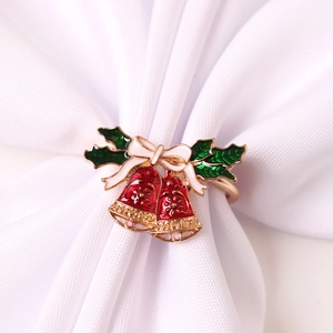 Détail d'un rond de serviette de Noël avec cloches rouges, houx vert et décoration de nœud blanc