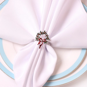 Détail du rond de serviette houx de Noël avec baies rouges sur une serviette blanche