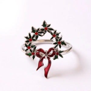 Détail d'un rond de serviette couronne de Noël avec feuilles émaillées et nœud rouge
