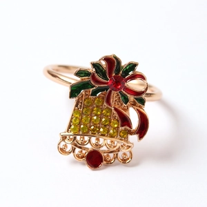 Détail d'un rond de serviette en cloche de Noël dorée avec nœud rouge et strass brillants