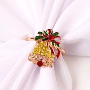 Détail du rond de serviette cloche dorée avec nœud émaillé rouge et cristaux