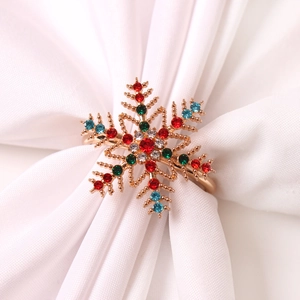 Détail d'un rond de serviette flocon de neige serti de strass colorés sur tissu