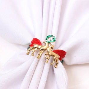 Detailed view of festive golden reindeer napkin ring with colorful enamel finish