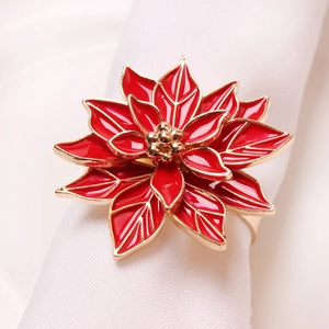 Elegant red poinsettia napkin ring with gold accents for Christmas dining table decoration