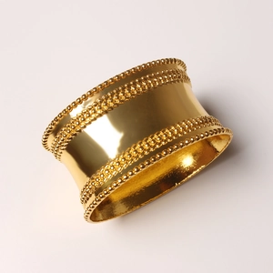 Golden oval napkin ring with beaded edges and polished mirror finish on white background