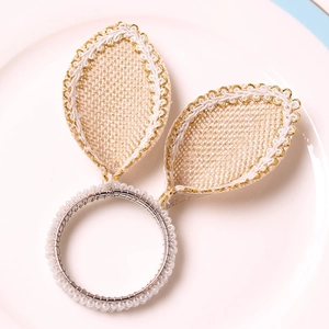 Detailed shot of burlap rabbit ear napkin ring with white beads on a white ceramic plate