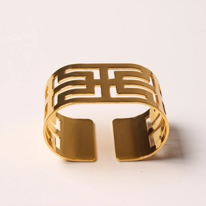Close-up of golden hollow geometric pattern napkin ring with polished metal finish