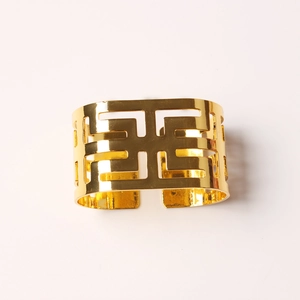 Macro shot of gold hollow geometric napkin ring with elegant Greek key patterns