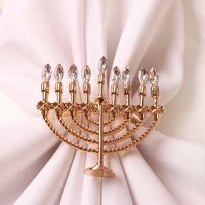 Elegant gold Menorah napkin ring with 9 clear rhinestones on white cloth napkin