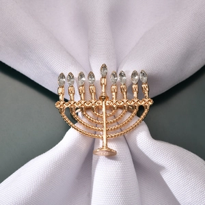 Detail of golden Menorah napkin ring featuring nine branches with white rhinestones