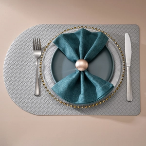 Rose gold metal napkin ring set with woven placemat and linen napkin for dining