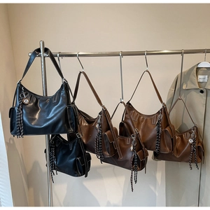 Vintage-Tasche mit Fokus auf die Seitentasche und den gewebten Quastenanhänger