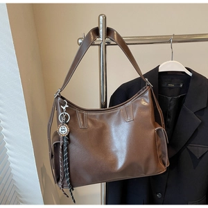 Detailansicht der braunen Ledertasche mit Kontrastnähten und Seitentaschen