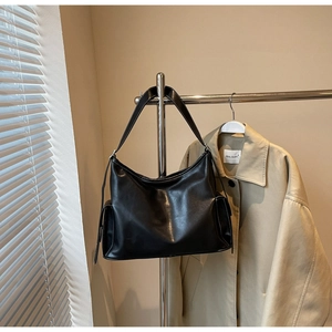 Detail der schwarzen Hobo-Tasche aus Leder mit Kontrastnähten und funktionaler Seitentasche