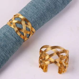 Elegant gold woven metal napkin rings set of 2 with intricate hollow mesh design on table