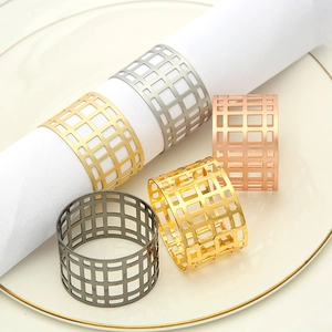 Detailed close-up of hollow geometric metal napkin rings in four elegant metallic finishes